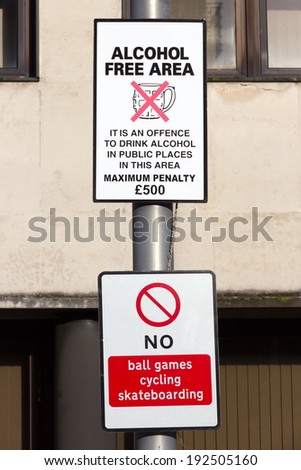 Street sign warning that the area is a no alcohol zone to prevent drunken behaviour. Below is a no ball games, cycling, skateboarding sign