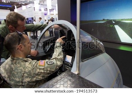 BERLIN, GERMANY - MAY 21: US soldier gets instructions in a military jet simulator at the International Aerospace Exhibition ILA on May 2XXXXXXXXX1st, 2014 in Berlin, Germany.