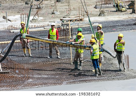 ANTWERP, BELGIUM - JULY 9: Workers pouring concrete for the bases of the new Antwerp Port Authority HQ on July 9, 2013 in Antwerp, Belgium. The new building will be build over a monumental building.