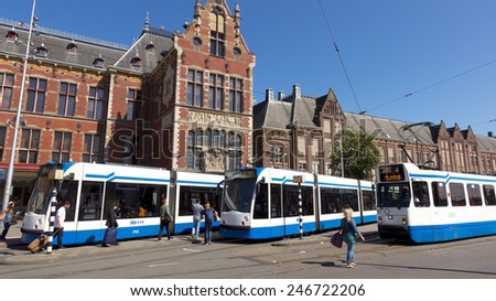 AMSTERDAM - AUGUST 27: Modern trams in front of Amsterdam Central Station on Augist 27, 2014 in Amsterdam, The Netherlands. The city\'s Tram network is the largest tram network in the Netherlands