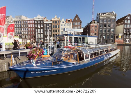 AMSTERDAM, NETHERLANDS - AUG 27 : Canal boat in front of typical Amsterdam canal houses on Aug 27, 2014. Amsterdam is the worlds most watery city. It has more than one hundred kilometres of canals.