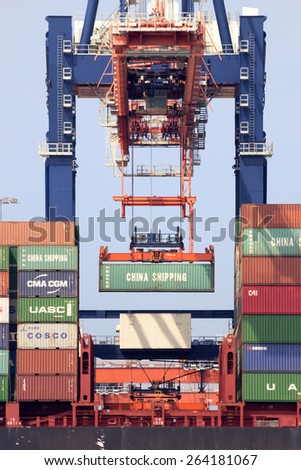 ROTTERDAM - AUG 1, 2014: Crane operator placing a container in a cargo ship the Port of Rotterdam. The port is the Europ\'s largest and facilitate the needs of a hinterland with 40,000,000 consumers.