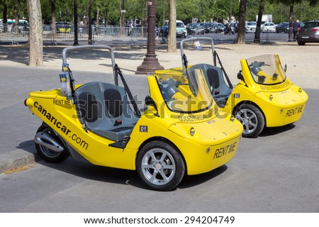 PARIS - JUN 19, 2015: Small two-seater convertible cars with an audio-guided system for rent to tourists in Paris. These vehicles from Canaricar drive at max 50 km/h.