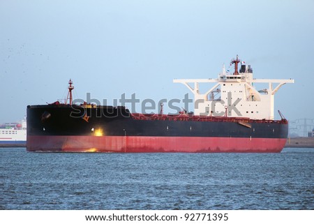 Large oil tanker leaving Rotterdam harbor at sunset