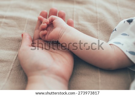 New born baby hand in mom\'s palm