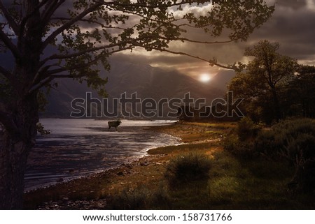 The sun breaks through the heavy cloud hanging over Loch Leven in the Highlands of Scotland.