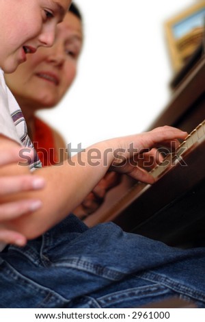 Piano teacher and student during a lesson.  The student\'s hands are the point of focus