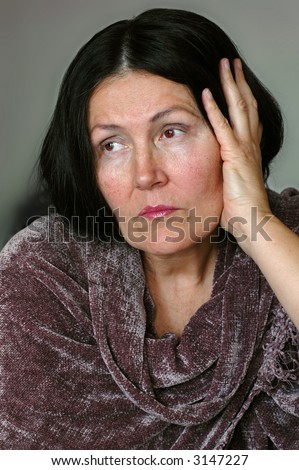 Older woman, sitting alone and looking away into the distance
