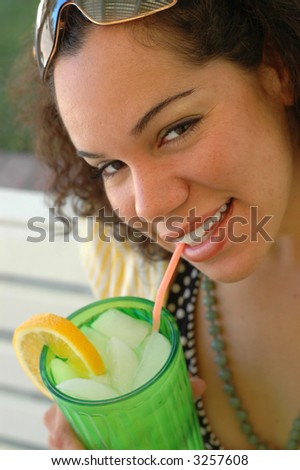 Attractive young woman drinking lemonade on a hot day