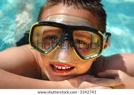 Closeup headshot of a kid in a diving mask having summer fun in the cool, clear water