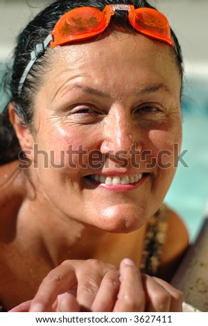 Headshot of a gorgeous woman in her late fifties working out in the pool