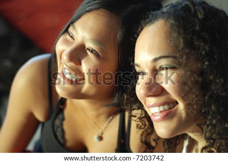 Two girlfriends laughing and having fun; shallow depth of field and natural light