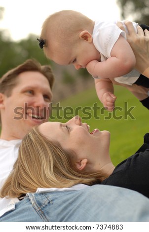 Close knit family of three playing around in the park and having a blast of it