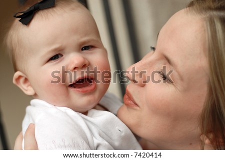 Attractive young woman showing off her pretty little baby girl