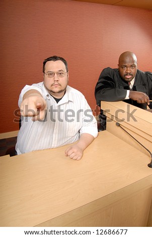 Man serving as a witness as trial pointing at the viewer