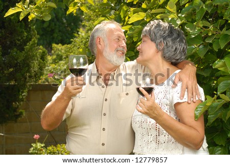 Lovely senior couple dining al fresco with wine glasses