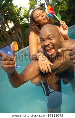 Happy young couple having fun outside in the pool