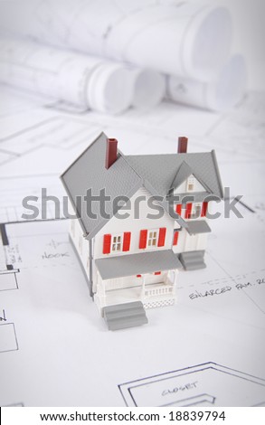 Home building concept shot with blueprints and small home model