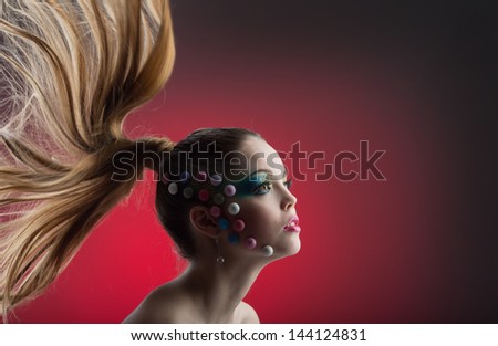 Beautiful young girl with her hair fly on a red background