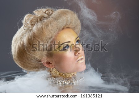 Portrait of Beautiful lady with voluminous hair style and bright make up in gold colors