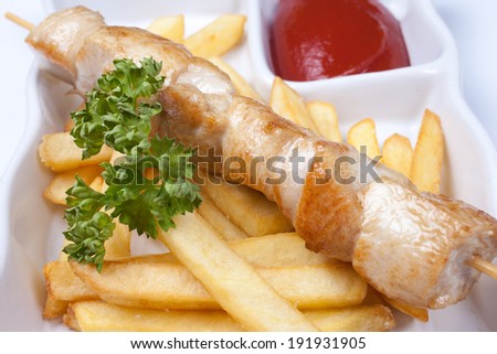 Delicious dinner consisting of chicken and french fries with tomato sauce