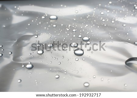 Small drops of fresh clean water on the silver gray surface