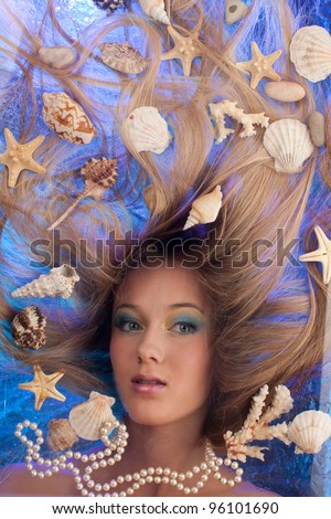 beautiful girl among the shells with her hair