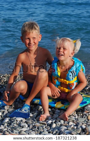 Girl of 3 years (blonde) with the elder brother on the seashore