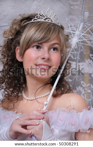 Portrait of the bride in a white dress with a diadem in hair and with an umbrella