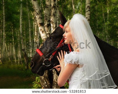 The bride in a wedding dress walks in wood with a horse