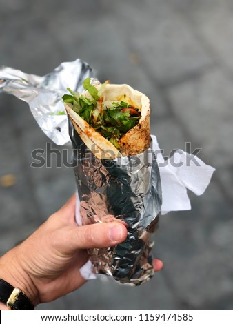 Chicken curry wrap with salad wrapped in foil from a street food market