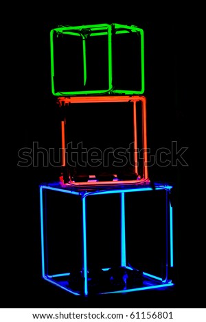 Stack of green, red and blue neon cubes on a black background.