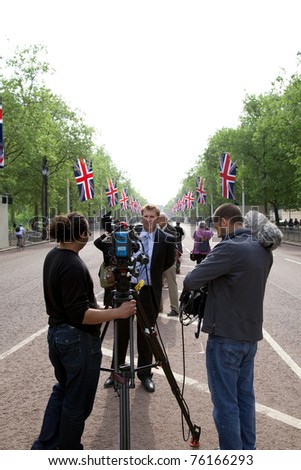 LONDON, UK - APRIL 26: An unidentified news team films prior to the Royal Wedding on April 26, 2011. They are along The Mall towards Buckingham Palace in London, UK. The Royal Wedding will be widely covered in the media.