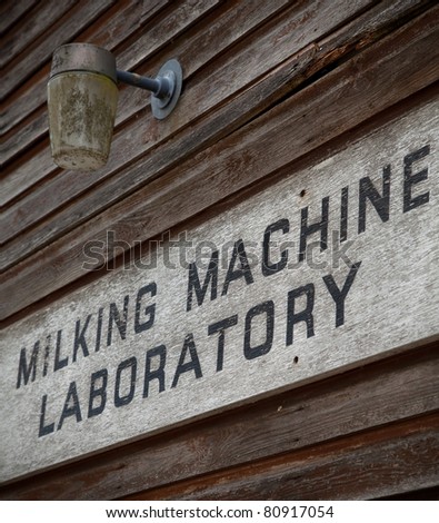 Grunge sign at the entrance to a Milking Machine Laboratory.