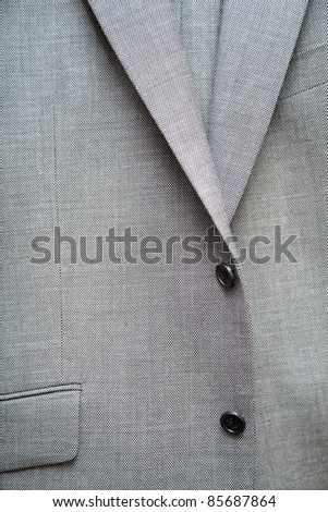 Grey single-breasted suit with buttons and pocket.