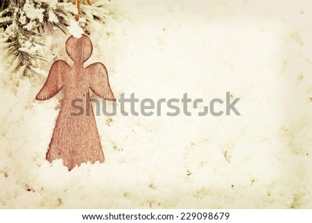 Vintage wooden Christmas angel decoration on snow background Vintage wooden Christmas angel decoration on snow background