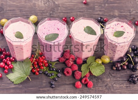 Four glasses of various fresh berries smoothies top view
