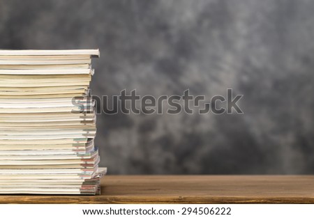 Stack of magazines on left side of table with copy space