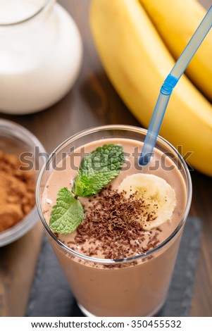 Glass of chocolate banana smoothie with straw top view