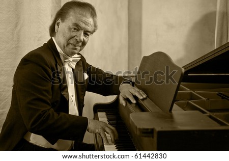 Senior man pianist playing on a grand piano. Nikolai Massenkoff, the star of the Massenkoff Russian Folk Festival.