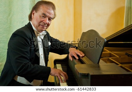 Senior man pianist playing on a grand piano. Nikolai Massenkoff, the star of the Massenkoff Russian Folk Festival.