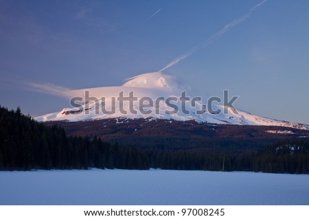 Mount Hood. View of snow capped Mt. Hood with frozen lake and forest in foreground, Oregon, U.S.A.