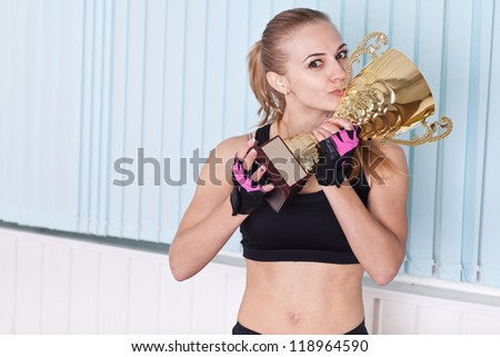 woman kissing cup awards for his win