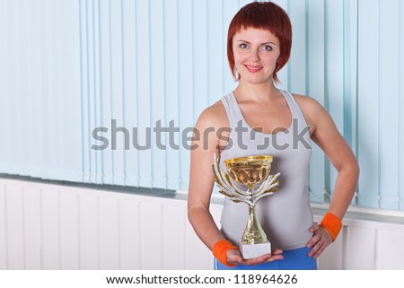 woman holding cup awards for his win