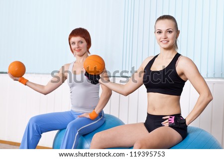 two fitness woman do exercises with hard ball