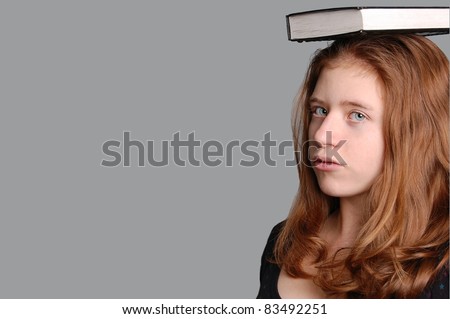 A Pretty, Young, Red Headed Woman with a Textbook on her head, with Room for Text