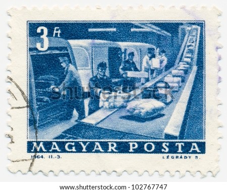 HUNGARY - CIRCA 1964: A stamp printed in the Hungary shows Mail workers unload machine guards on the conveyor, circa 1964