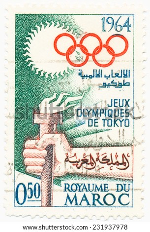 MOROCCO - CIRCA 1964: A stamp printed in Morocco shows The hand with the Olympic torch and rings, Olympics in Tokyo, circa 1964