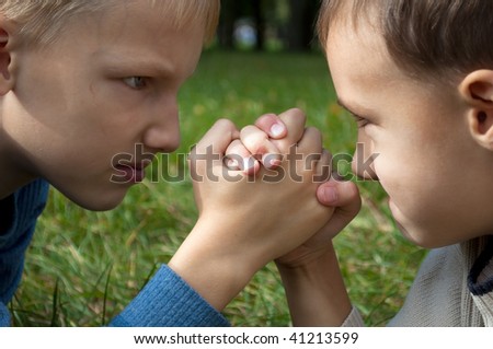Two brothers fight on his hands on the grass