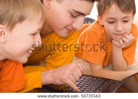 three brothers played on the laptop in orange shirts
